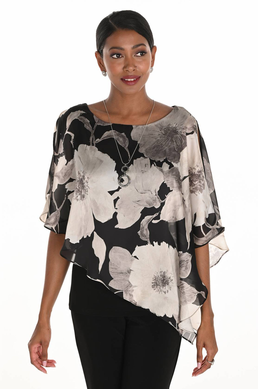 Woman wearing a floral blouse with black, white, and gray pattern on a white background